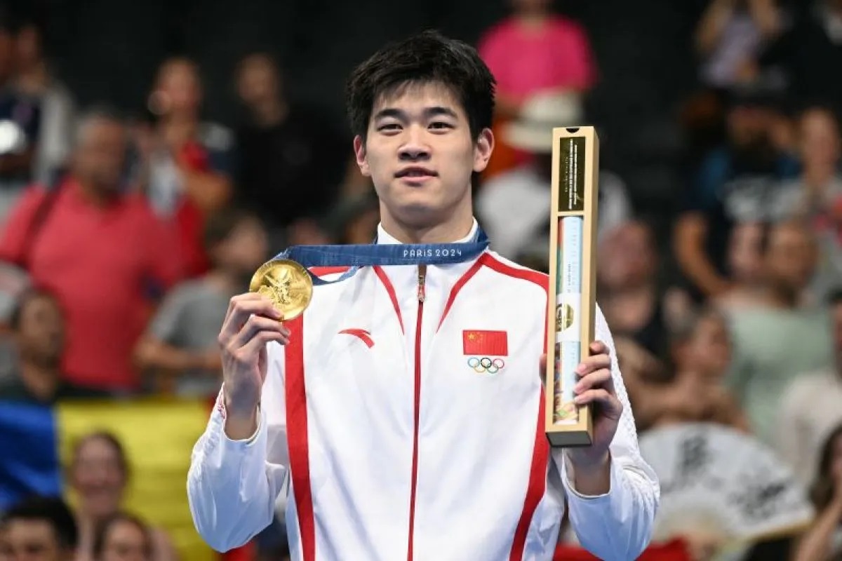 Peraih medali emas atlet renang China Pan Zhanle berpose dengan medalinya di podium nomor renang gaya bebas 100m putra pada Olimpiade Paris 2024 di Paris La Defense Arena di Nanterre.