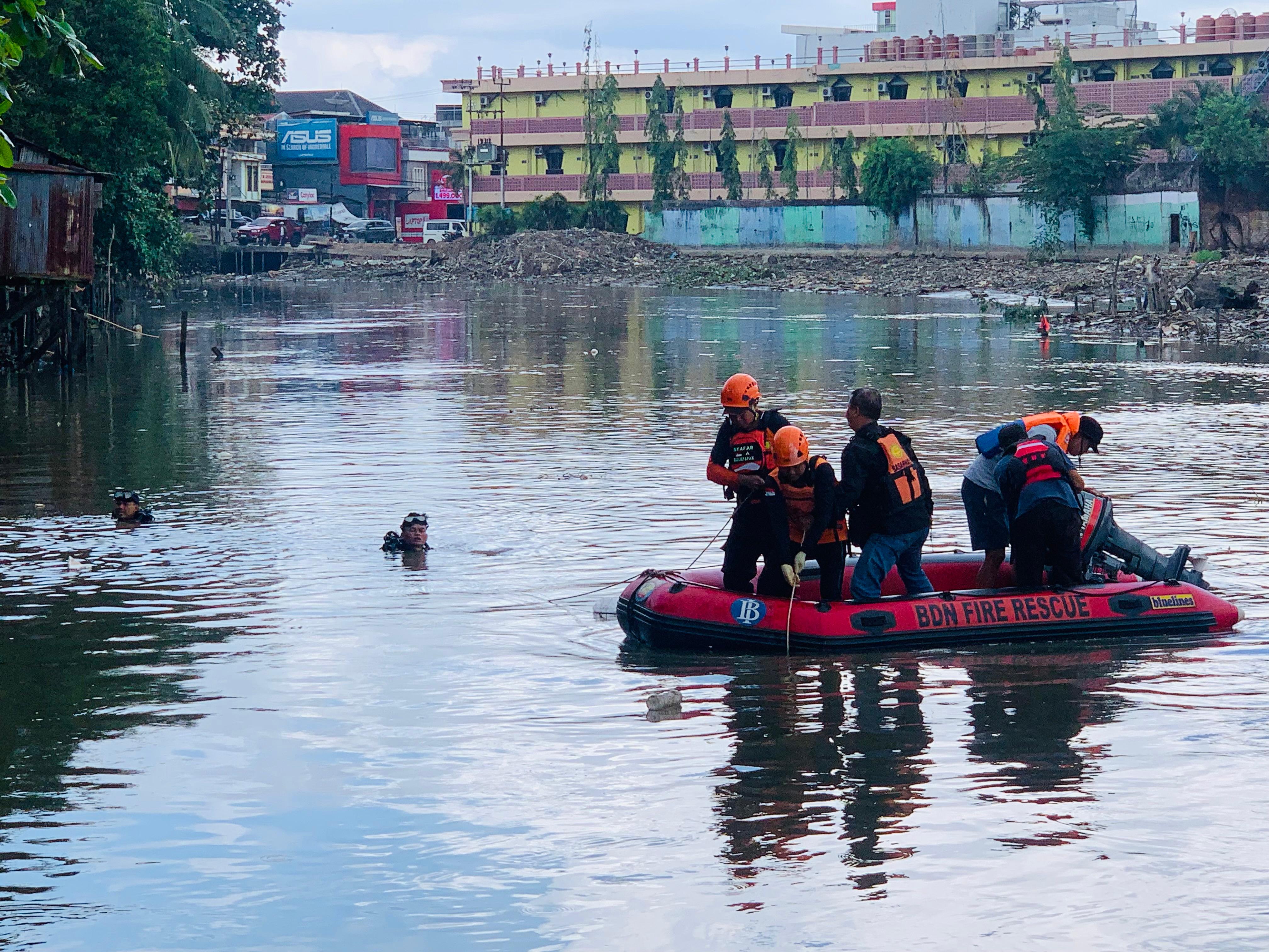 Petugas menyusur sungai mencari korban.