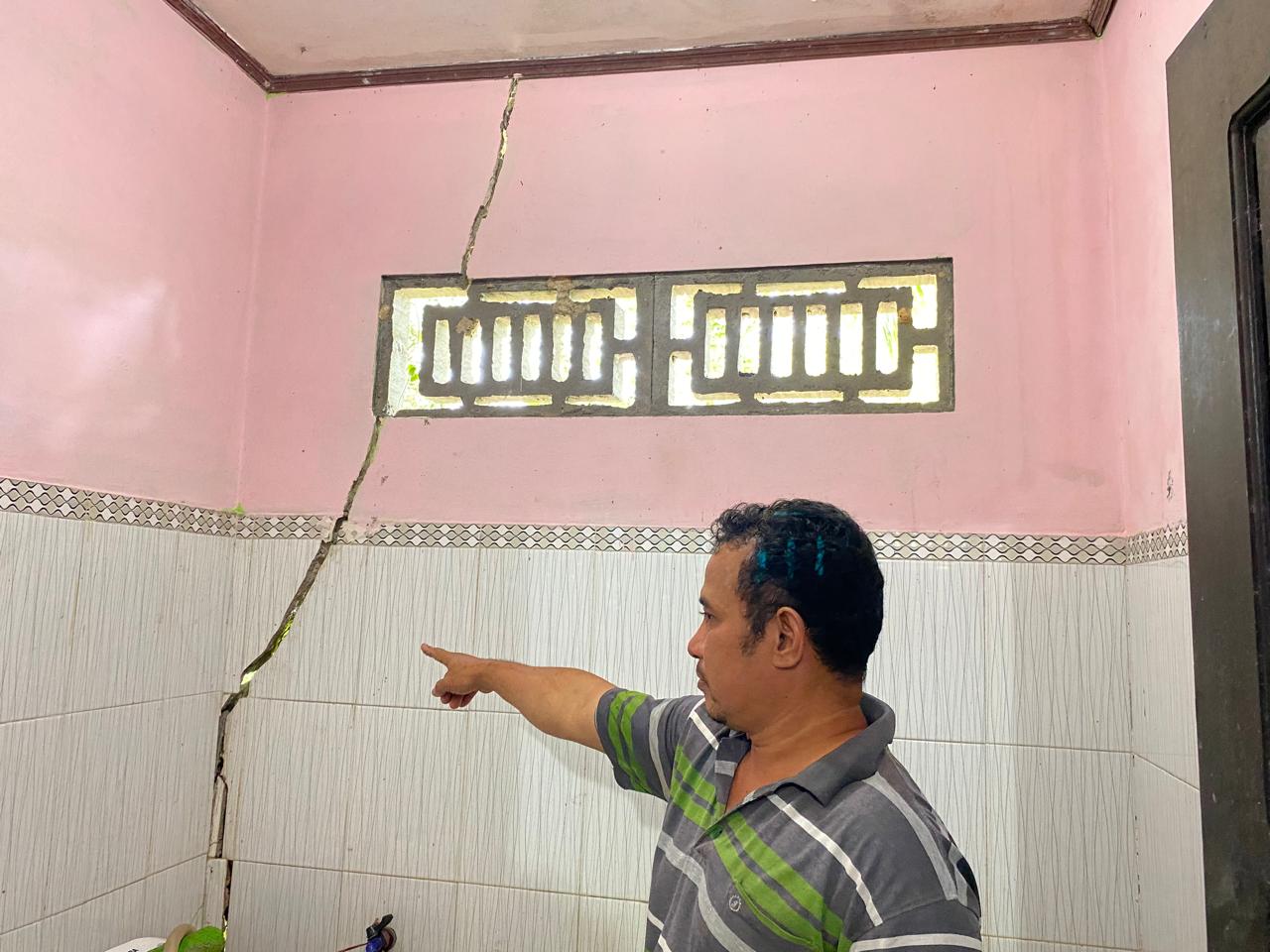 Warga menunjukkan retakan yang timbul di dinding kamar mandi Ketua RT 43, Subroto, Rabu (31/7/2024) siang. (Foto : Erik Alfian/Prokal.co)