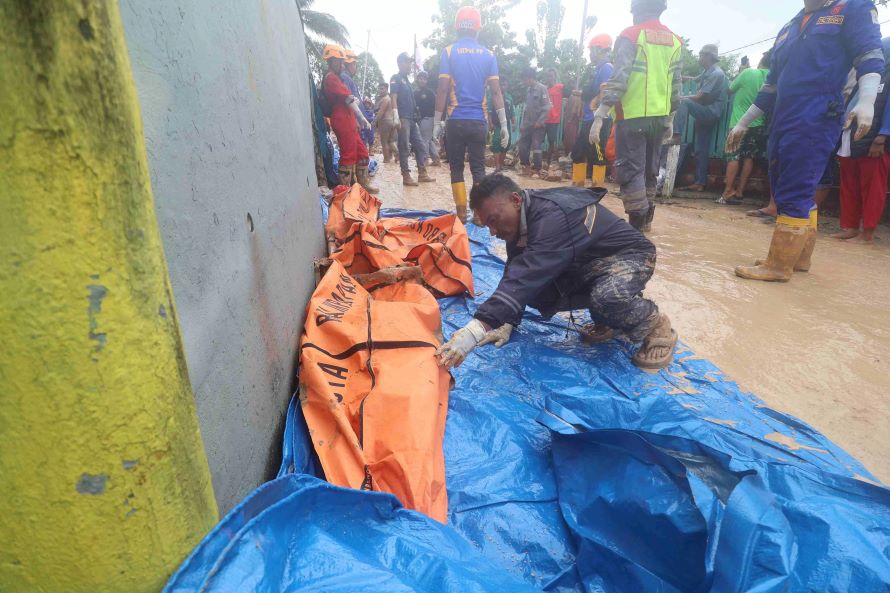 EVAKUASI: Jenazah dari longsoran di TPU Gunung Guntur, Balikpapan diamankan dalam kantong oleh petugas. (Foto: Anggi/KP)