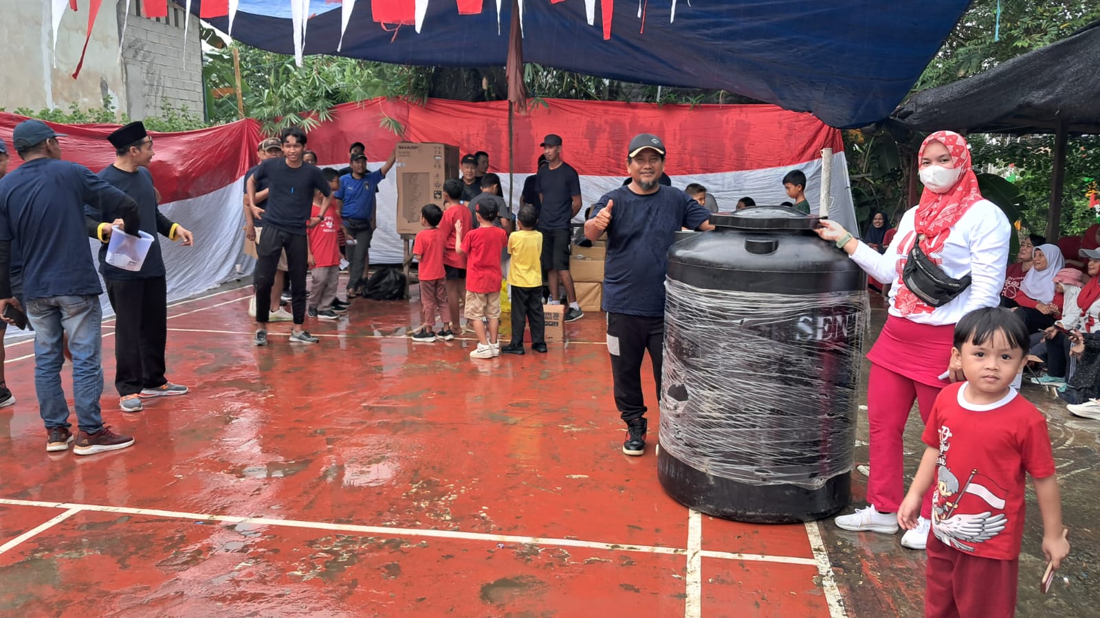 DOORPRIZE: Ketua RT 58, Kelurahan Graha Indah, Kecamatan Balikpapan Utara, Musta&rsquo;in (kiri) dan warga peraih hadiah tandon air, Minggu (25/8/2024).