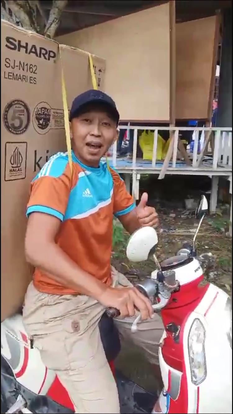 SEMRINGAH: Salah seorang warga RT 58 yang membawa pulang hadiah kulkas.
