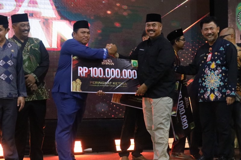 Bupati Kukar Edi Damansyah saat menyerahkan penghargaan Anugerah Desa Idaman 2024 Bidang Pengelolaan Keuangan Desa, Pengelolaan Aset Desa dan Pengelolaan BUMDes di Gedung Putri Karang Melenu (PKM), Te