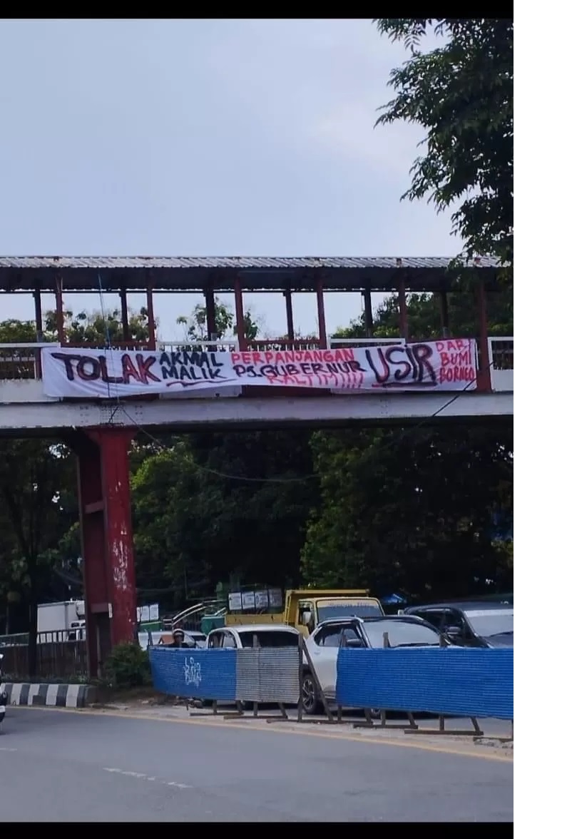 DITOLAK. Spanduk berisi penolakan terhadap Pj Gubernur Kaltim Akmal Malik terpasang di jembatan penyebrangan Jalan Juanda, Samarinda Ulu.