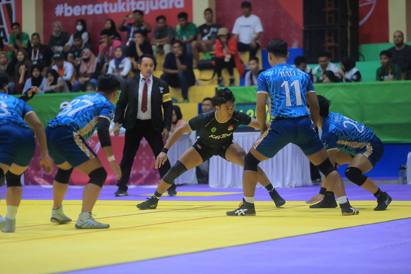 Pemain kabaddi Kaltim (hitam) saat berhadapan dengan Bali, pada final kelas 7 for five putra, di GOR Lubuk Pakam, Deli Serdang, Jumat (13/9/2024).