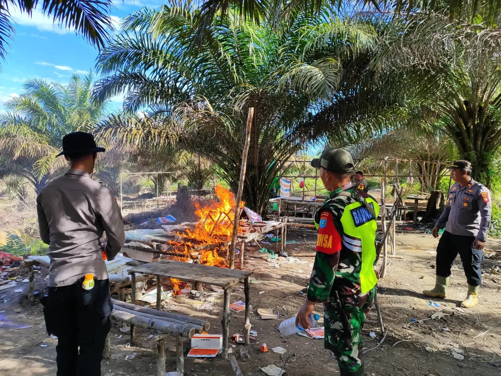 TINDAK TEGAS: Petugas Polsek Sajingan Besar membakar sejumlah peralatan Pertambangan Emas Tanpa Izin (PETI) di Kecamatan Sajingan Besar.(ISTIMEWA)