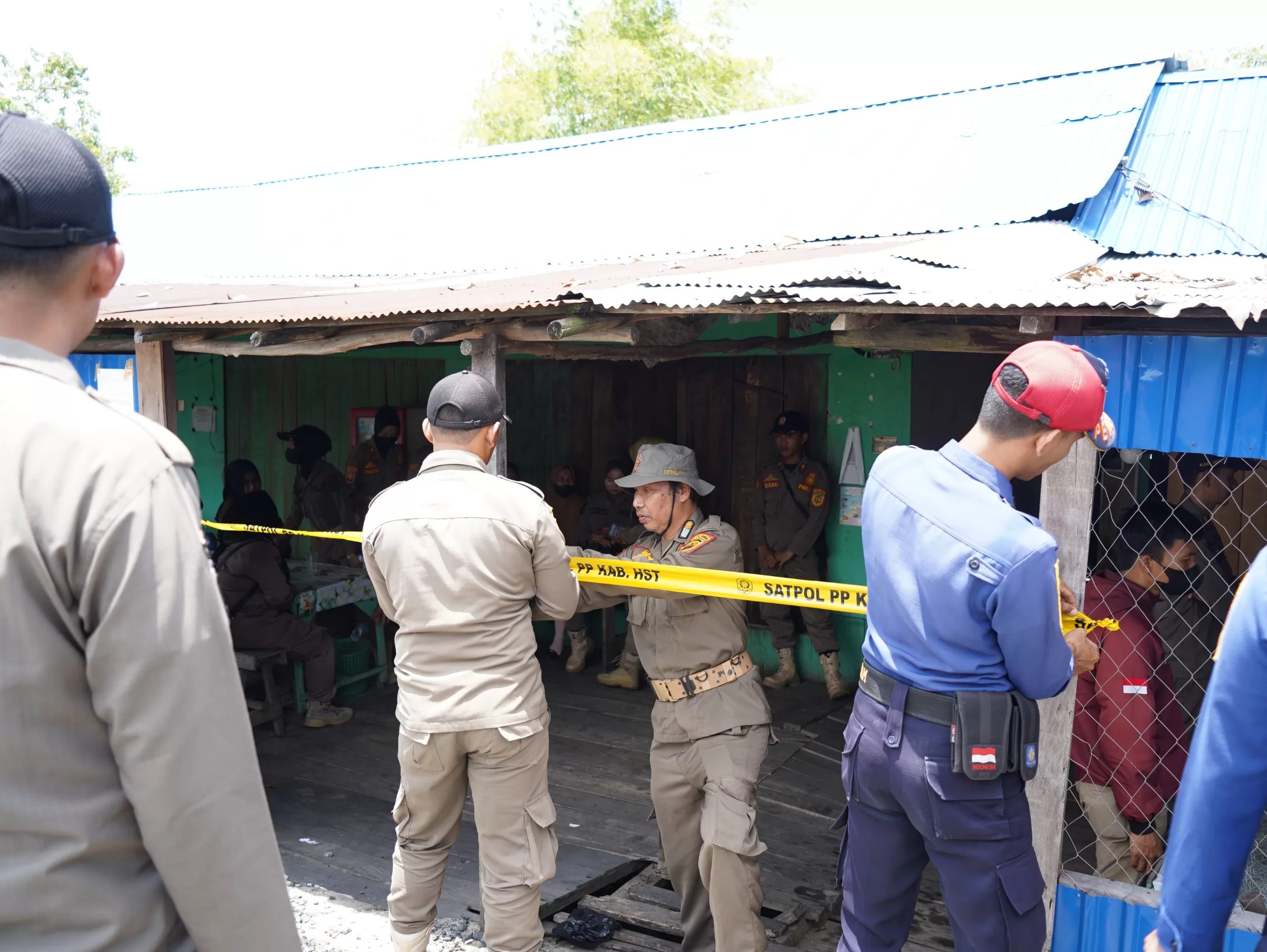 DISEGEL: Satpol PP HST memasang garis kuning di Warung yang ada di Desa Sungai Buluh. (Foto: Satpol PP HST untuk Radar Banjarmasin)