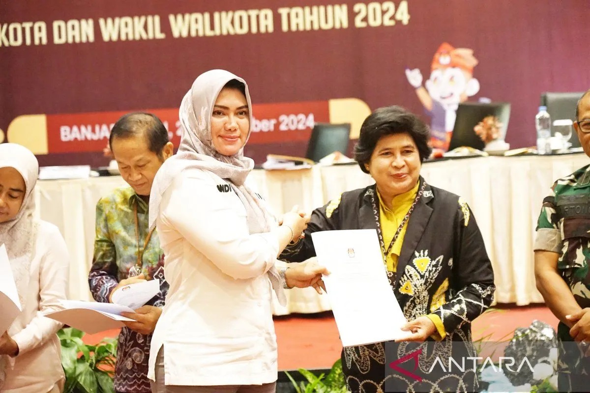 Ketua KPU Kalsel Andi Tenri Sompa menyerahkan berita acara DPT kepada Kasubdit VIP Dit Pamobvit Polda Kalsel AKBP Nina Rahmi yang mengikuti rapat pleno terbuka rekapitulasi DPT tingkat Provinsi Kalsel