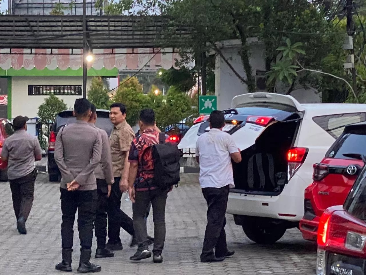 USAI MENGELEDAH. Tim penyidik KPK ketika keluar dari kantor DPMPTSP dengan membawa koper berisi hasil penggeledahan.