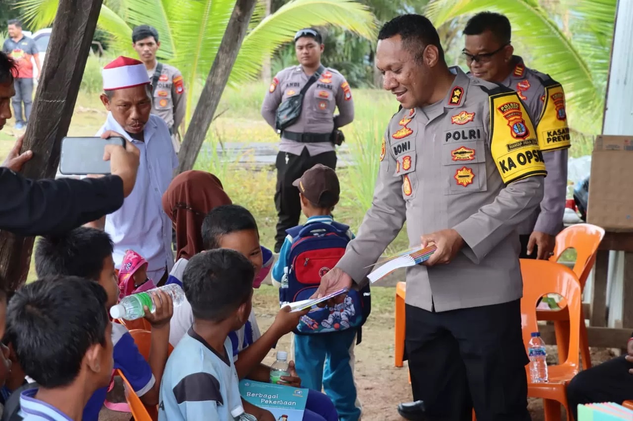 BERBAGI BUKU: Kapolres Nunukan, AKBP Bonifasius Rumbewas saat memberikan buku kepada anak-anak WNI yang tinggal di wilayah perbatasan Indonesia-Malaysia.