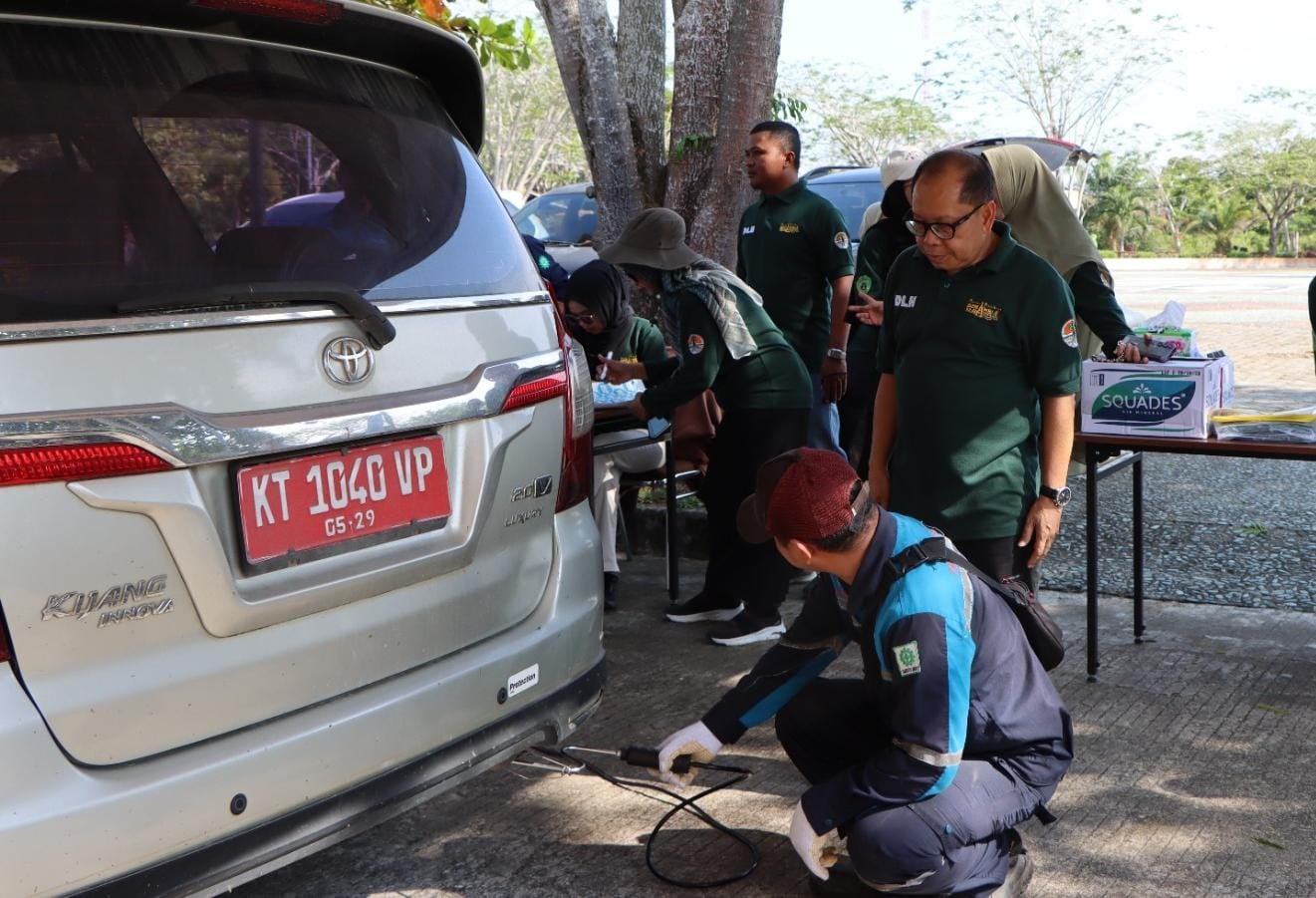 BERSIH: Safwana (berkacamata) memantau uji emisi untuk kendaraan dinas Pemkab PPU di halaman kantor DLH PPU, Selasa (15/10).