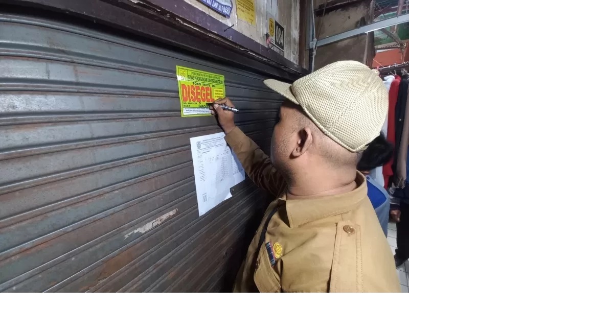 SEGEL: Petugas Disperdagin Banjarmasin menyegel kios di Pasar Kuripan, Senin (21/10) lalu. Sanksi itu diberikan kepada pedagang yang menunggak retribusi. (Foto: RIYAD DAFHI RIZKI/RADAR BANJARMASIN)