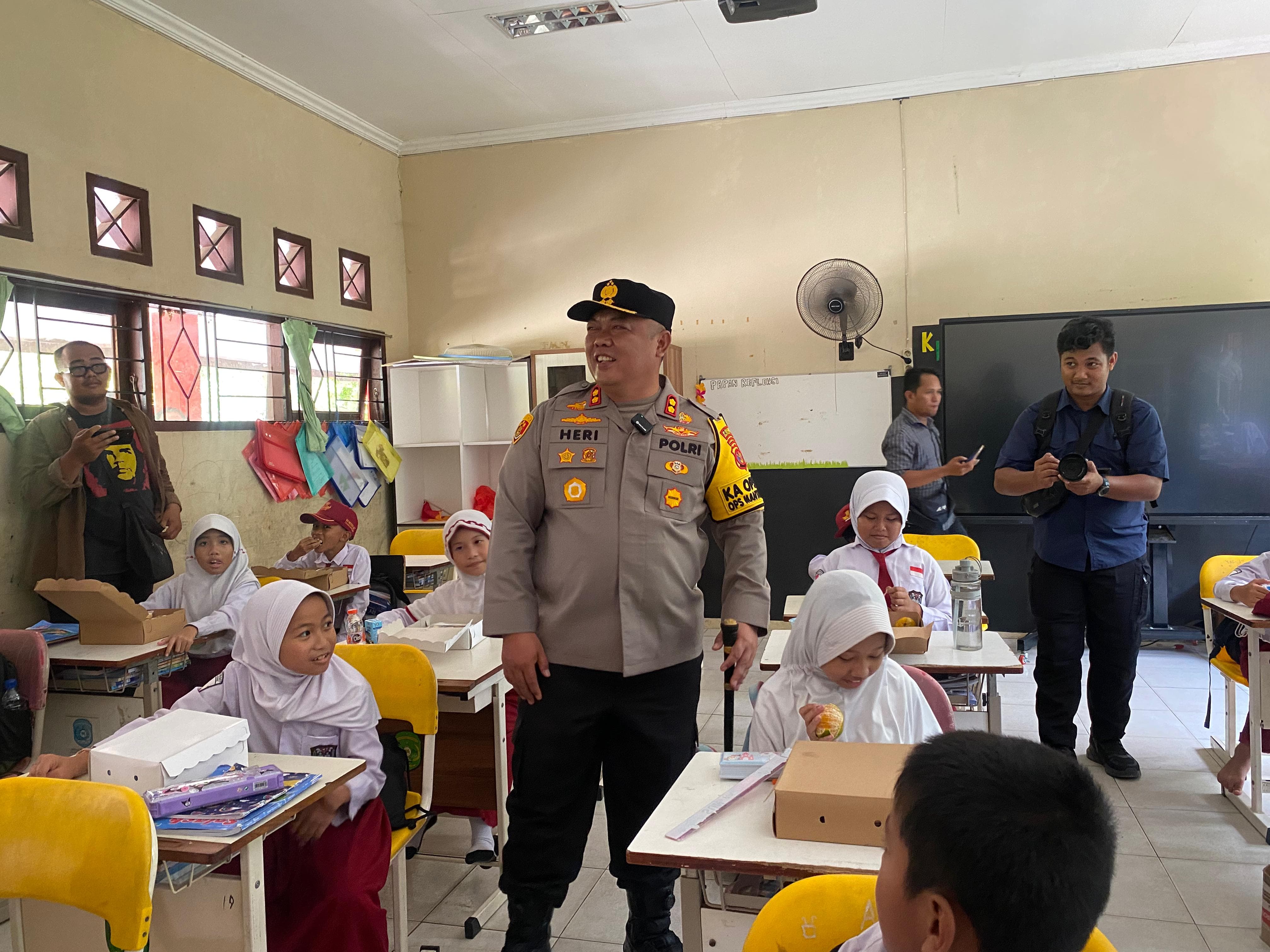 Kapolres Kukar AKBP Heri Rusyaman memantau pembagian makanan bergizi gratis ke SD Negeri 007 Tenggarong (Elmo/Prokal.co)
