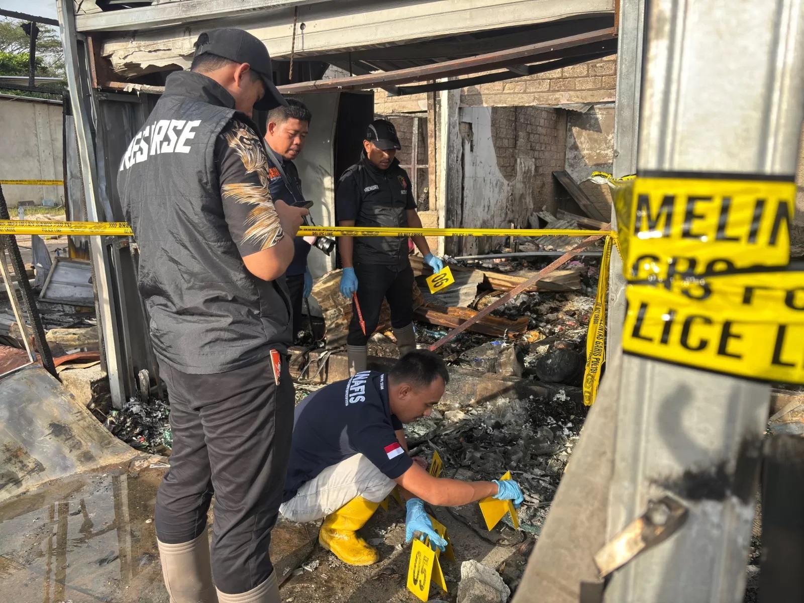 MENYELIDIKI: Personel Unit Inafis Satreskrim Polres Tarakan melakukan olah TKP di kios yang diduga asal api.