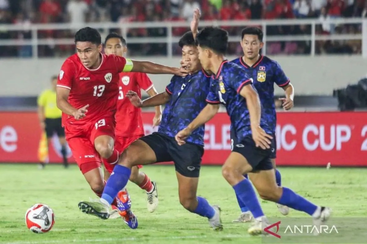 Pesepak bola Timnas Laos Phetdavanh Somsanid (ketiga kanan), Anantaza Siphongphan (kedua kanan) dan Phoutthasay Khochalern (kanan) berusaha merebut bola dari pesepak bola Timnas Indonesia M Ferarri.