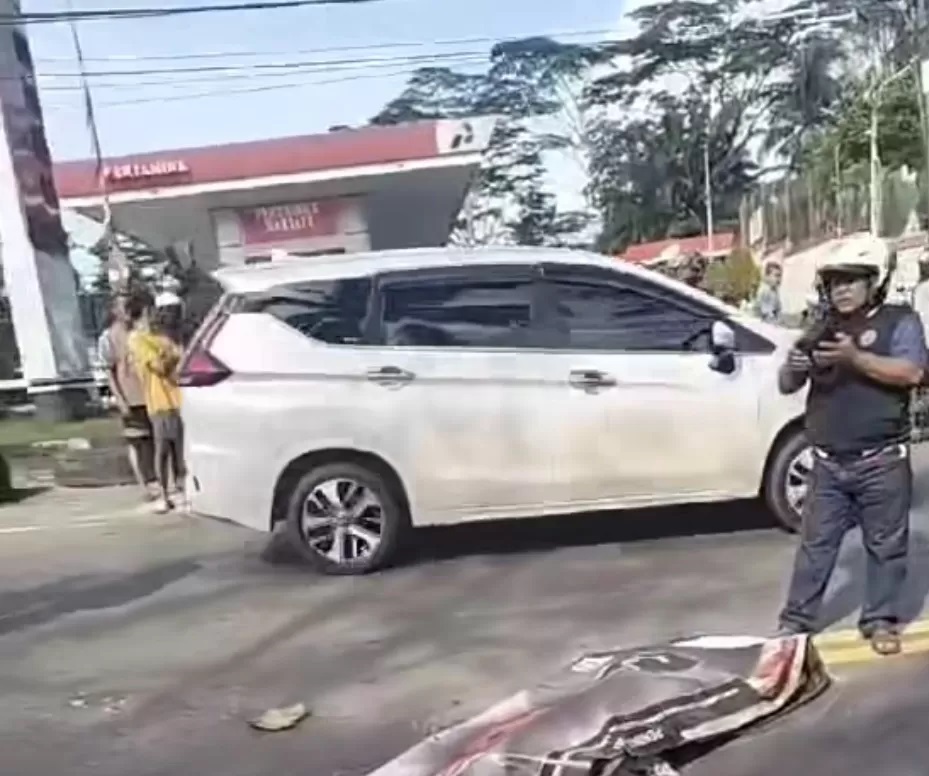 TEWAS DI TEMPAT: Jasad perempuan penumpang sepeda motor berinisial ASY ditutup dengan spanduk di lokasi kecelakaan Jalan Soekarno-Hatta KM 9, Balikpapan Utara. (ISTIMEWA)