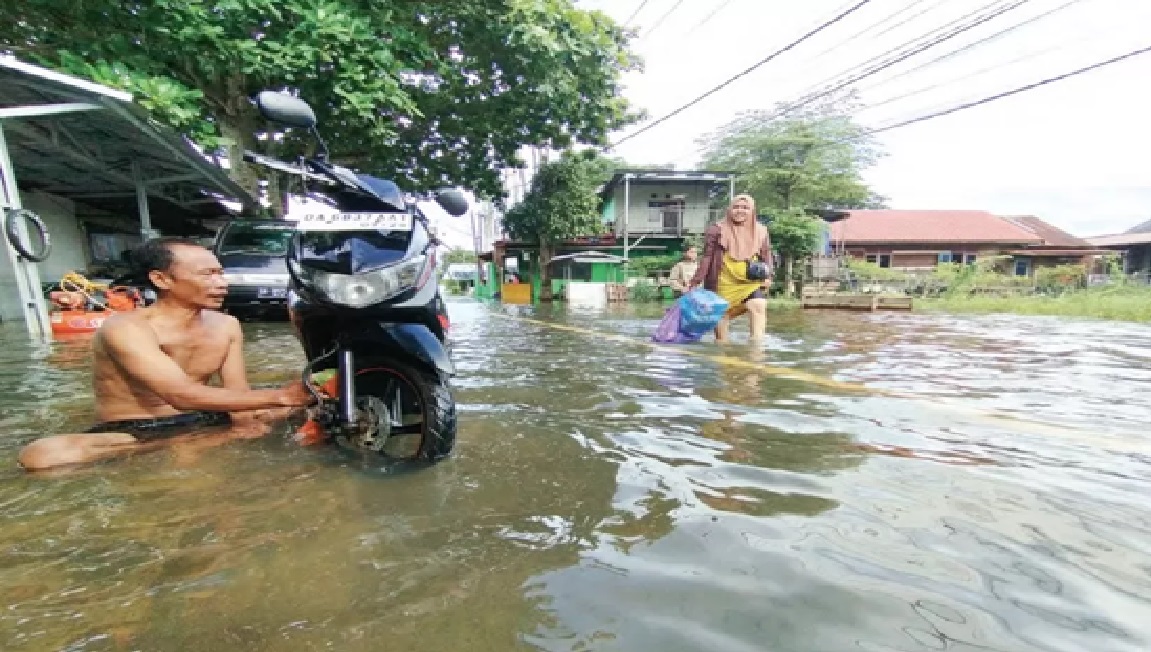 TERENDAM: Sejumlah guru di SDN Pekauman 1 memeriksa kondisi banjir yang merendam sekolahnya pada Jumat (17/1). (Foto: M FADLAN ZAKIRI/RADAR BANJARMASIN)