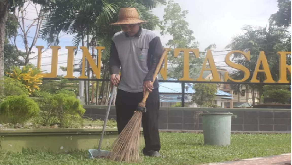 INSPIRATIF: Muhammad Rahmani Abduh, 25 tahun, saat menyapu taman kampus UIN Antasari Banjarmasin, Jumat (17/1) pagi. (Foto: RIYAD DAFHI RIZKI/RADAR BANJARMASIN)