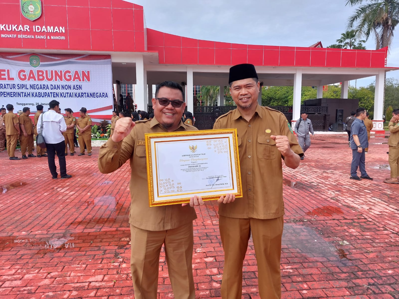 Kepala DPMD Kukar Arianto bersama Sekdis Yusran Darma memegang Panji Keberhasilan Pembangunan Wilayah Pedesaan terbaik kedua di Kaltim (Elmo/Prokal.co)