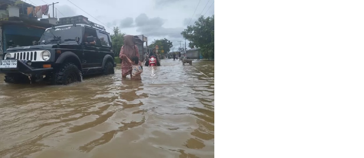 TERENDAM: Ibu menuntun anaknya saat melintasi banjir di Desa Pekauman, Kecamatan Martapura Timur, Kabupaten Banjar (Foto: FADLAN ZAKIRI/RADAR BANJARMASIN)