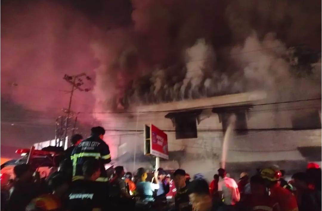 Petugas coba memadamkan api.