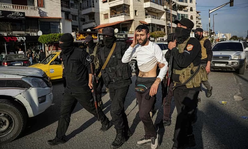 Seorang pria ditahan pasukan keamanan Suriah dalam sebuah bentrokan, Sabtu 8 Maret 2025. (FOTO: EPA)