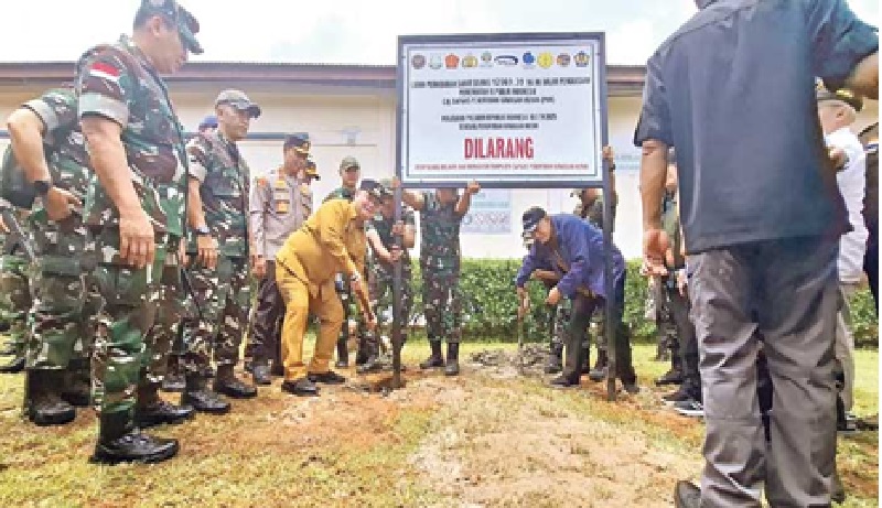 PENYITAAN: Bupati Kotim Halikinnor bersama sejumlah pejabat tinggi dari aparat penegak hukum memasang plang sitaan terhadap lahan perkebunan di Kotim, Selasa (18/3). (RADO/RADAR SAMPIT)