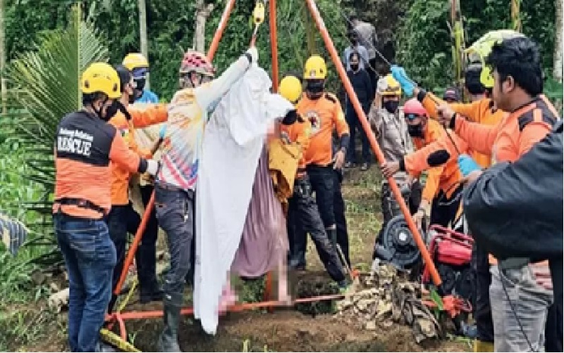 TOLAK OTOPSI: Proses evakuasi jenazah lansia yang tercebur ke dalam sumur melibatkan petugas gabungan.