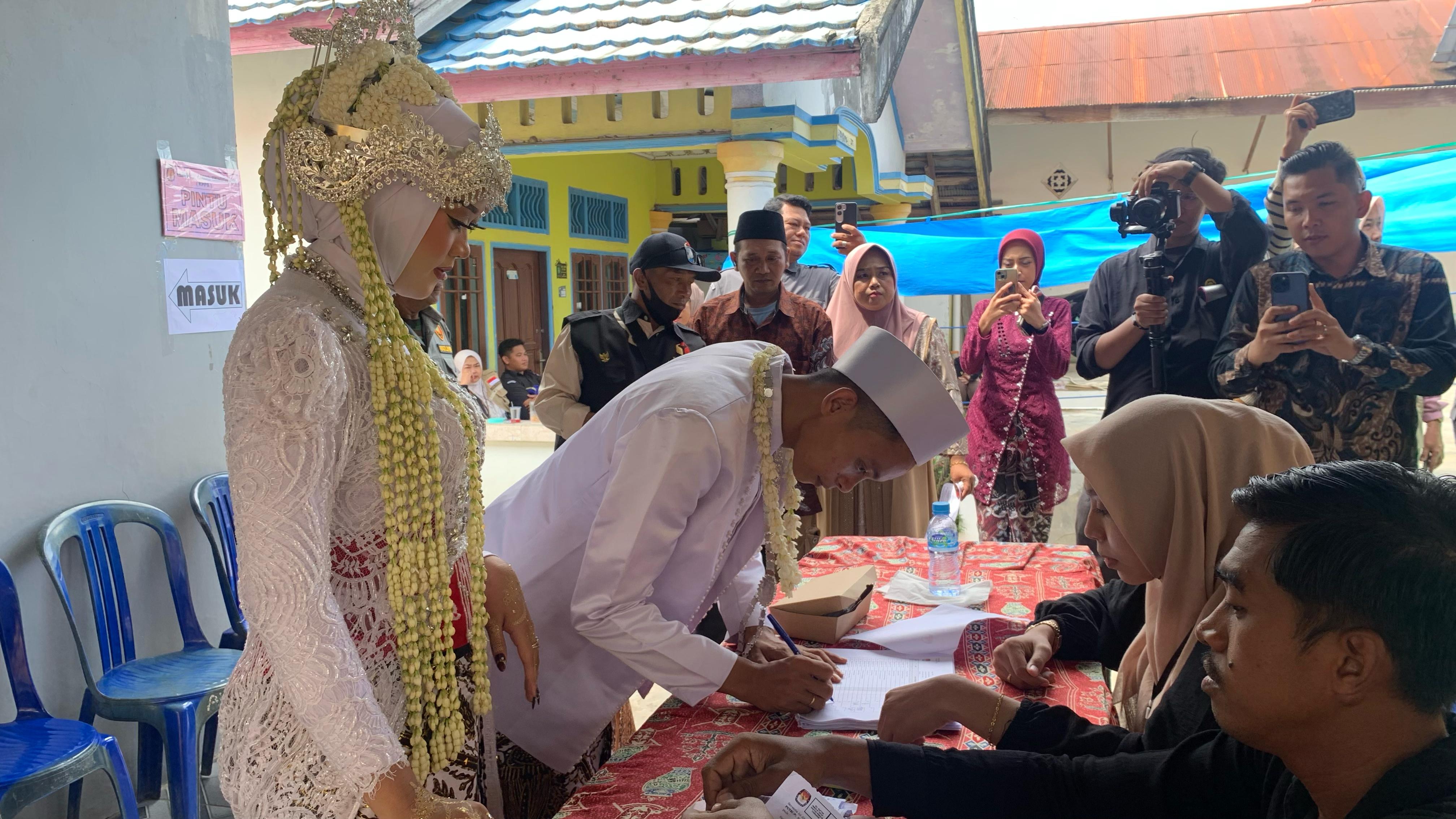 Pasangan pengantin Ahmad Mudzakir dan Fadila Widiana Putri mencoblos untuk PSU susulan di TPS 03 Desa Bukit Raya, Tenggarong Seberang (Elmo/Prokal.co)