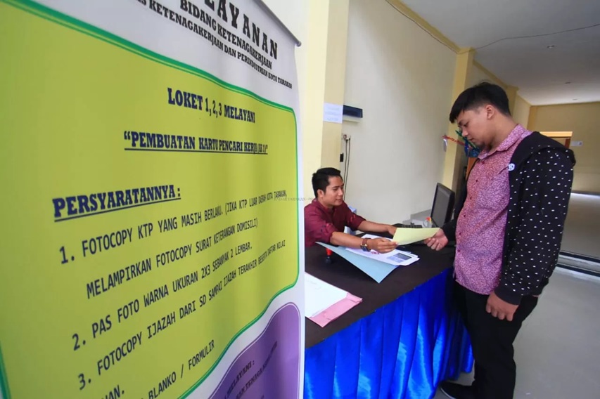 CARI KERJA: Pencari kerja melihat persyaratan pendaftaran. FOTO: DOK/RADAR TARAKAN