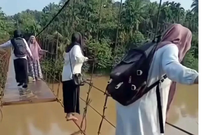 NEKAT: Perjuangan sejumlah guru SD di Jambi menyeberangi jembatan bolong dan rusak demi bisa mengajar di sekolah. (Instagram/@manangsoebeti_story )
