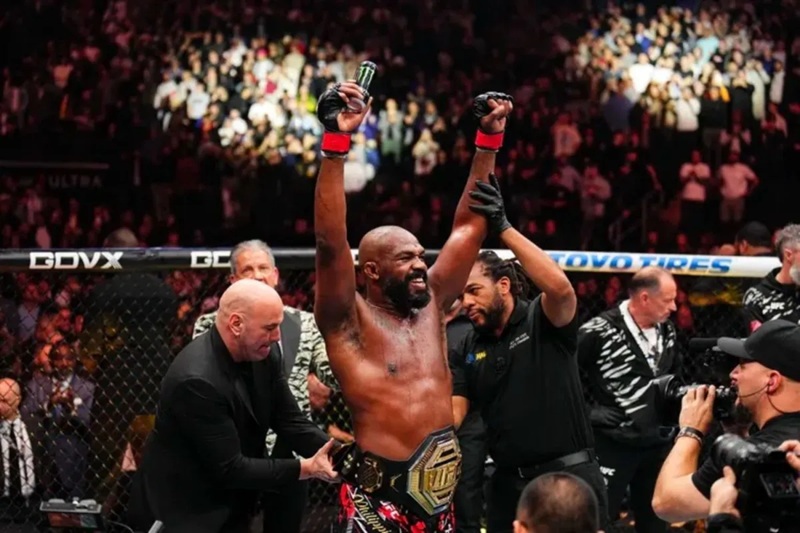 CEO UFC Dana White (kiri) memasang sabuk juara kelas berat di pinggang Jon Jones (kedua kanan). (Laman MMA Fighting)