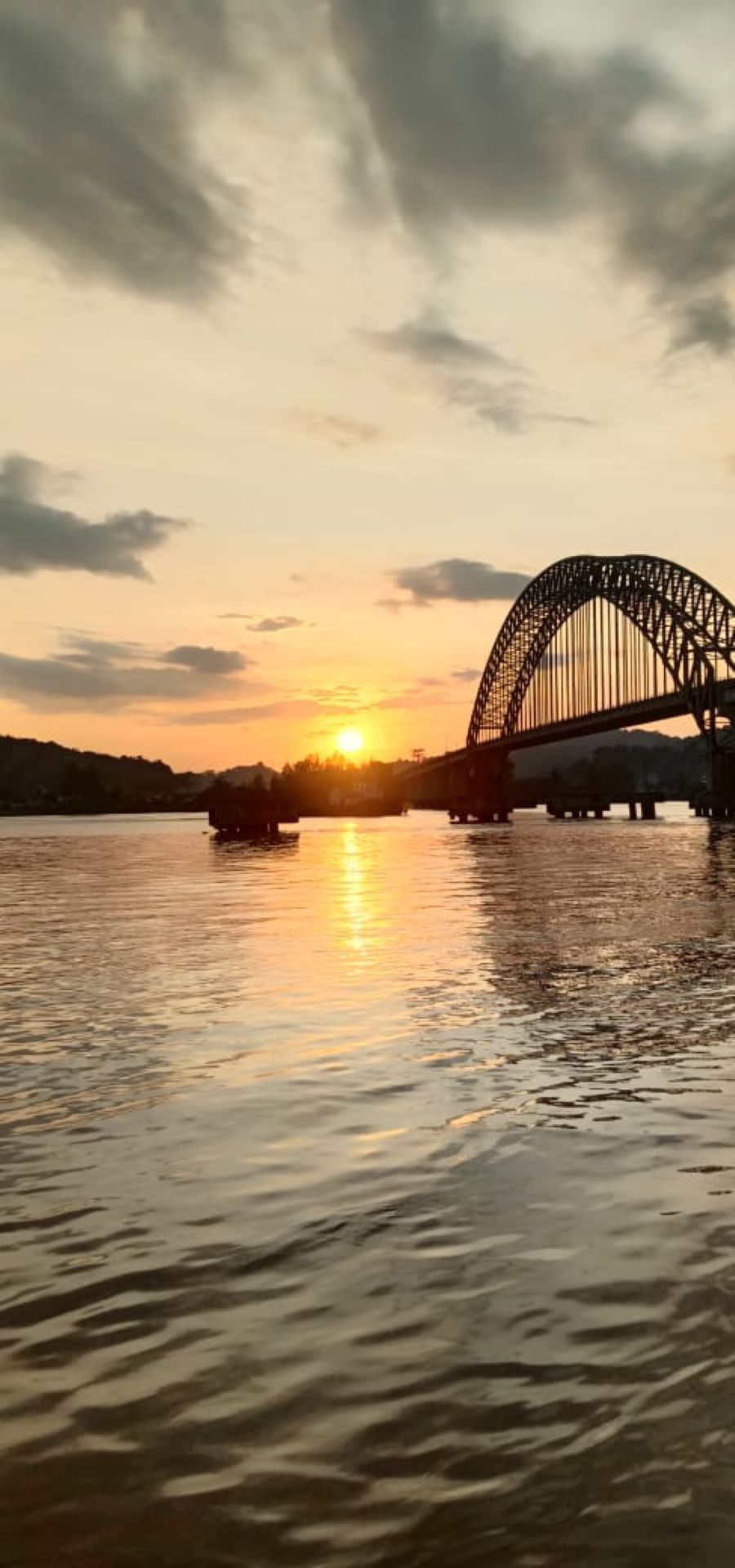 Jembatan Mahulu diabadikan saat senja. Fender jembatan saat masih lengkap, meskipun pipa besi penghubungnya sudah hilang dicuri.