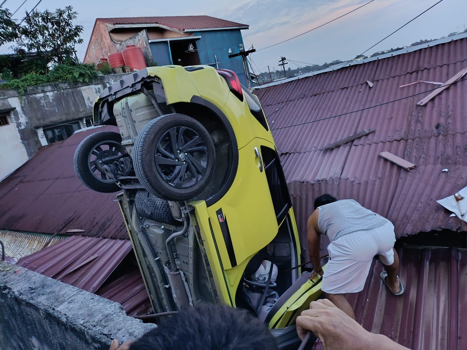 Posisi mobil yang jatuh di atap rumah warga. (sumber foto: grup koordinasi Info Bencana Balikpapan)