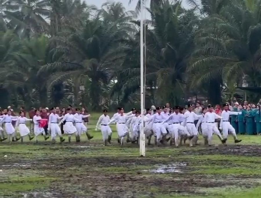 Perjuangan petugas upacara di Kelurahan Jahab, Tenggarong yang melaksanakan tugasnya meski di lapangan berlumpur (Istimewa)