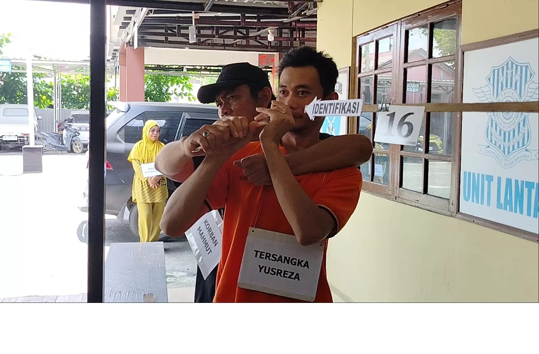 PERLAWANAN:Tersangka Yusreza memperagakan adegan penikaman dalam rekonstruksi kasus pembunuhan di halaman Polsek Banjarmasin Barat. (Maulana/Radar Banjarmasin)