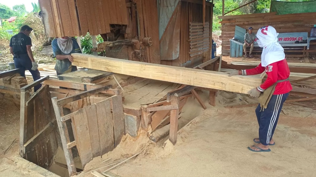 BELAH KAYU: Sejumlah pekerja penggergajian kayu sedang membelah satu batang kayu menggunakan mesin pemotong kayu, kemarin. Asosiasi Pelaku Industri Kayu mengeluhkan banyaknya gangguan.