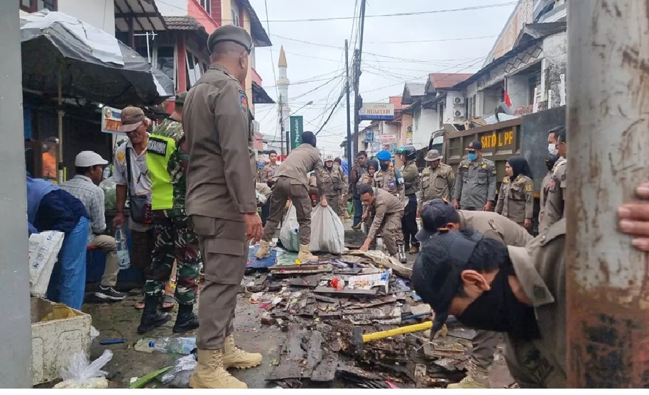 Petugas Satpol PP Samarind tengah membongkar dan menyita dagangan penjual kembang di Jalan KH Mas Tumenggung, Kelurahan Pasar Pagi, Kecamatan Samarinda Kota. (kis)