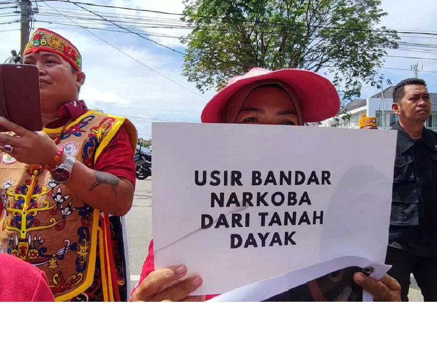 Peserta massa Gerakan Dayak Anti Narkoba (GDAN) membawa spanduk berisi pesan terhadap pengedar narkoba saat aksi unjuk rasa di PN Palangka Raya