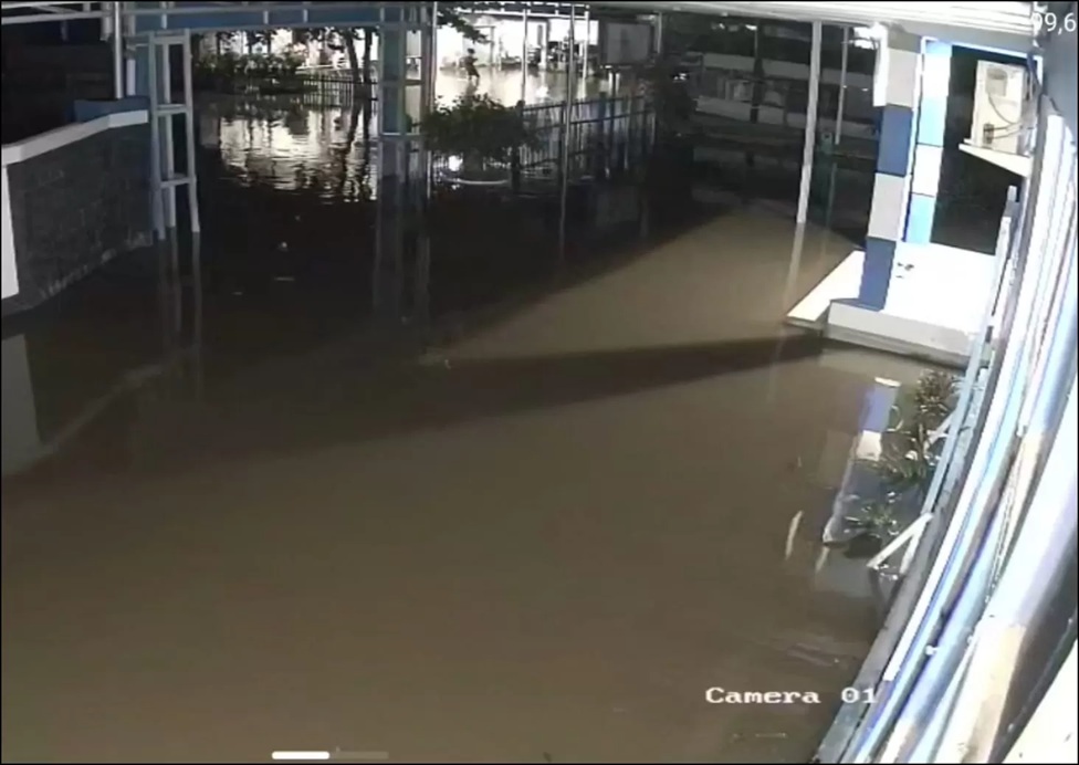 TERGENANG: Genangan rob menutup badan jalan di depan Kantor Camat Aluh-Aluh, Senin (8/12/2025) malam. (CAMAT ALUH-ALUH)