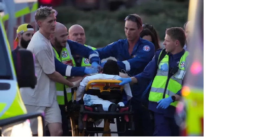 Petugas darurat mengevakuasi seorang korban dengan tandu setelah penembakan dilaporkan terjadi di Bondi Beach, Sydney, Australia, Minggu (14/12/2025). (ABC News)