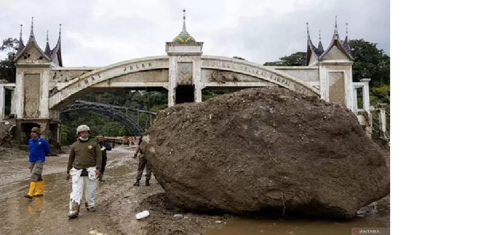 BATU BESAR: Petugas melintas di samping batu besar yang terbawa banjir bandang di jalan batas Kota Padang Panjang. (Muhammad Zulfikar/ANTARA)