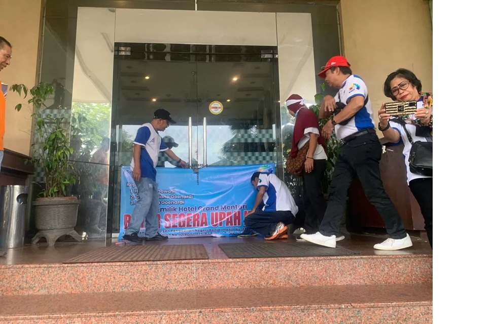 PROTES: Mantan karyawan Hotel Grand Mentari memasang rantai dan gembok di pintu masuk hotel sebagai bentuk protes atas belum dibayarkannya sisa pesangon, Sabtu (3/1/2026) pagi. (Foto: Endang S)