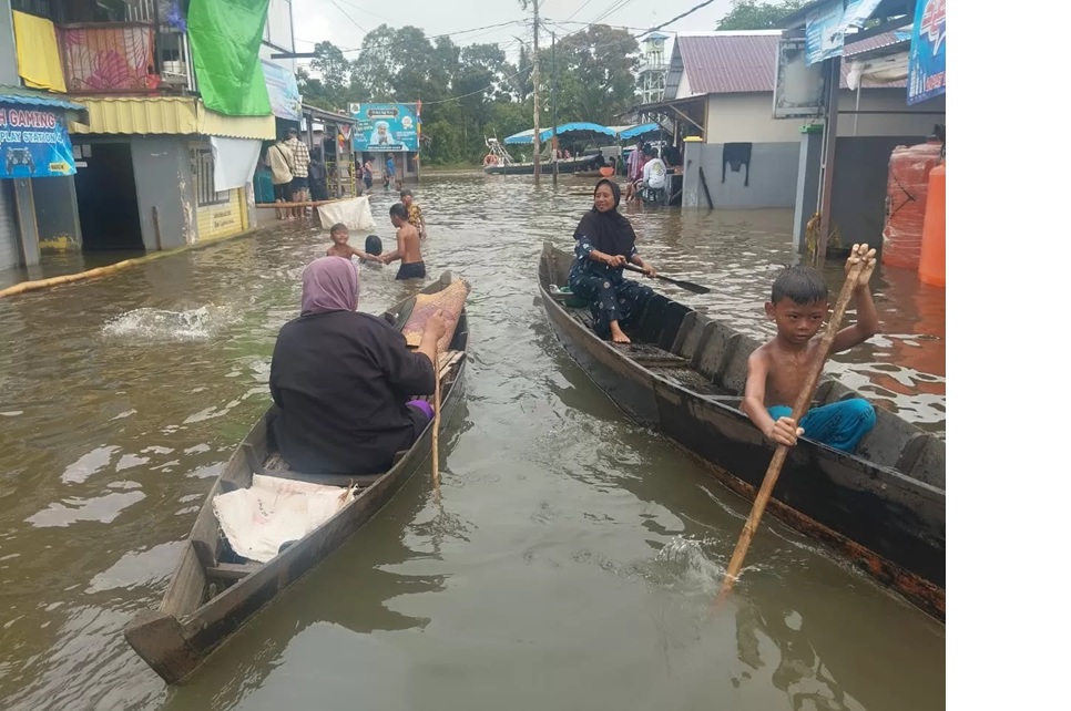 Aktivitas warga Desa Suggai Tabuk Keramat, Kabupaten Banjar di tengah kepungan banjir. Minggu (4/1/2026). Saat ini Pempov menunggu hasil audit lingkungan yang dilakukan KLH. (Foto: Fadlan Zakiri)