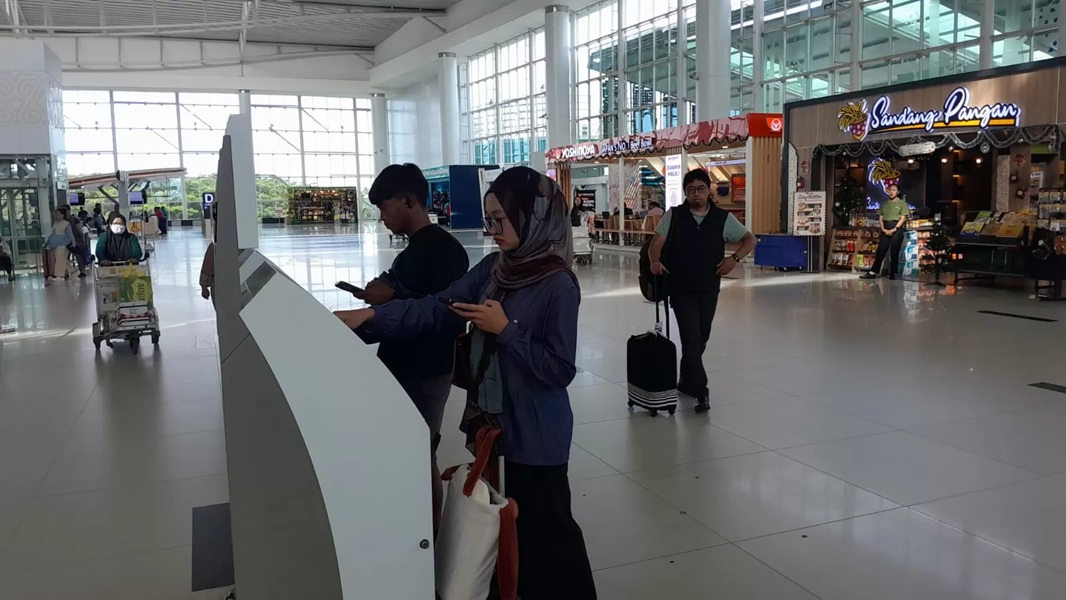 Penumpang memanfaatkan fasilitas self check-in di Bandara Internasional Sultan Aji Muhammad Sulaiman (SAMS) Sepinggan Balikpapan saat masa Angkutan Natal 2025 dan Tahun Baru 2026.