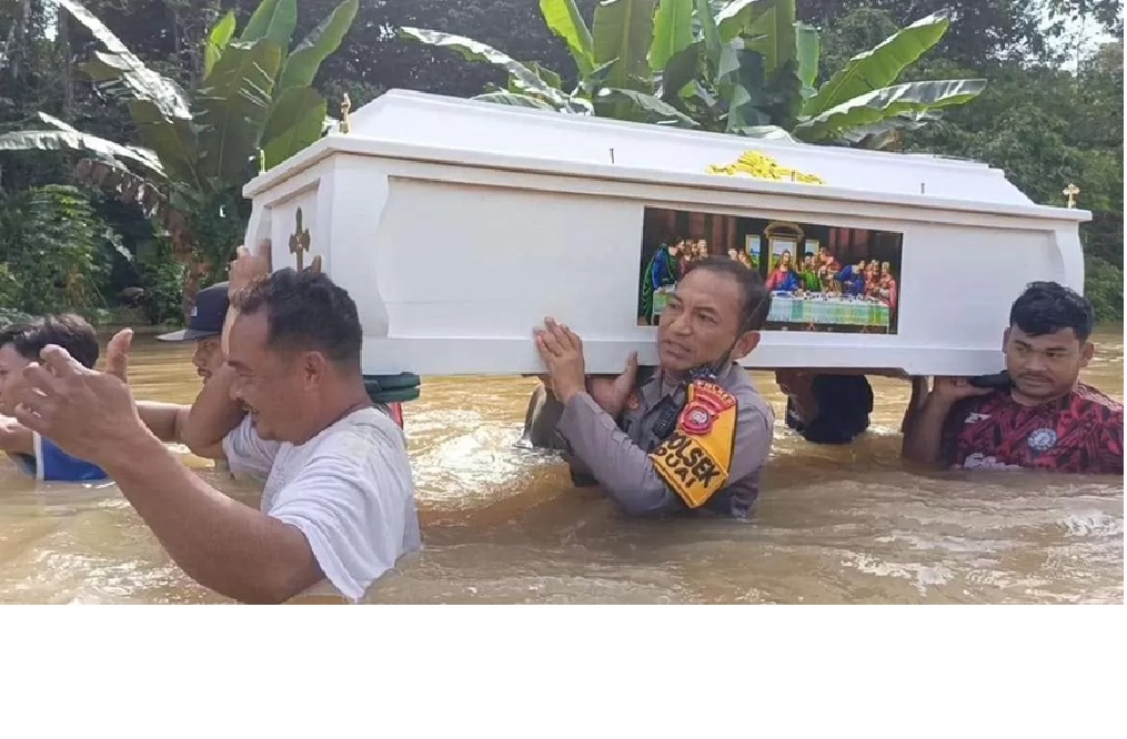 Warga dan polisi memanggul peti jenazah menembus banjir setinggi dada orang dewasa di Kecamatan Beduai, Kabupaten Sanggau, Minggu (11/1), akibat akses jalan terputus dan kendaraan tak bisa melintas.