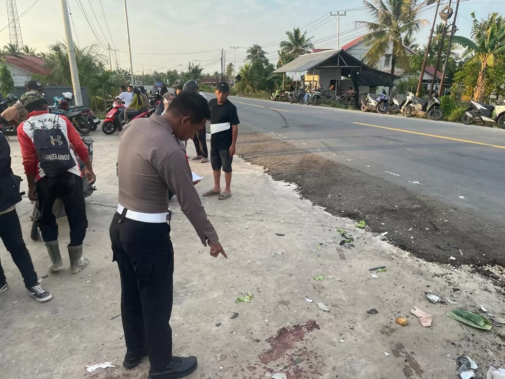 TKP: Anggota kepolisian menunjukan lokasi kecelakaan.