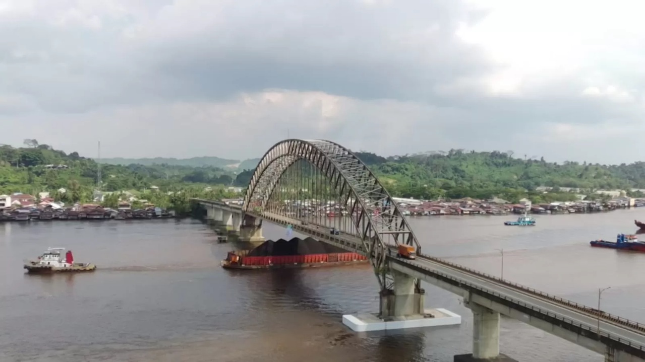 Tongkang batubara masih bergerak bebas melintasi Jembatan Mahakam Ulu meski spanduk larangan sudah terpasang. (kis)