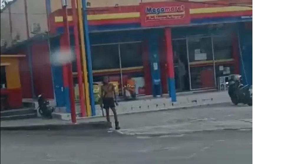 ODGJ membuat resah warga dengan aksinya menakut-nakuti pengguna jalan sambil membawa benda tajam di sekitar traffic light Jalan Samari, Pangkalan Bun. (Warga/Radar Pangkalan Bun)