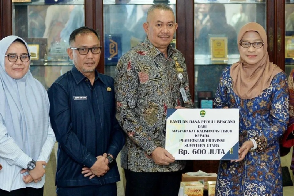 Penjabat Sekretaris Daerah Provinsi Sumut Sulaiman Harahap (tengah) menerima bantuan Rp600 juta yang diserahkan Sekdaprov Kaltim Sri Wahyuni di Kantor Gubernur Sumut.